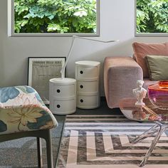 a living room filled with furniture and lots of green plants in the window sill