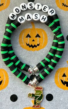 two bracelets with halloween decorations on them and one has a name tag that says monster mash