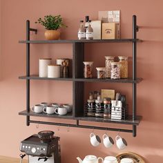 a shelf with coffee cups, teapots and other items on it in a room