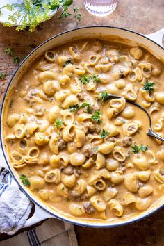 a pan filled with macaroni and cheese on top of a wooden table