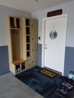 a room with blue carpet, white door and some shoes on the floor in front of it