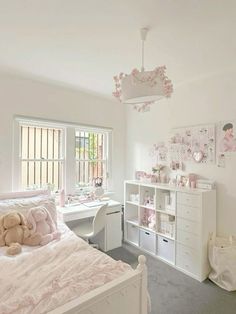 a bedroom with white furniture and pink decor