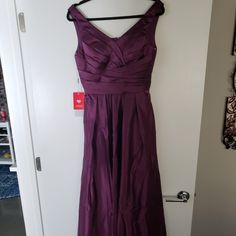 a purple dress hanging on a white door