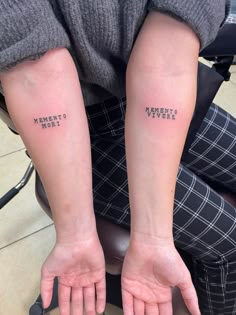 two people with matching tattoos on their arms