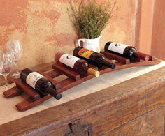 a wooden wine rack with four bottles on it