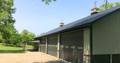 an image of a barn with a clock tower on the top and garage doors open