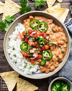 a bowl filled with rice, beans and veggies next to tortilla chips