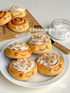 cinnamon rolls on a plate with cream cheese frosting in the middle and other pastries behind them