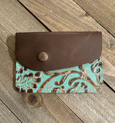 a wallet sitting on top of a wooden floor next to a brown and blue case