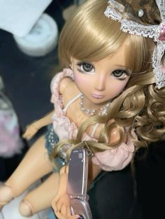 a doll holding a cell phone in her hand