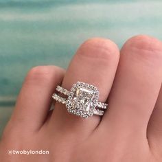 a woman's hand with a diamond ring on top of her finger and an engagement band