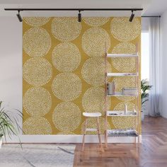 a yellow and white wallpaper with circles on it in an empty room next to a plant