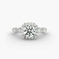 a diamond engagement ring on a white background with the center stone surrounded by small diamonds