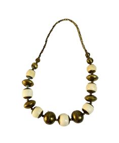 This vintage necklace features brass-capped ivory colored beads strung on a 26 inch strand. The beaded style and barrel closure give it a unique look, perfect for adding a vintage touch to any outfit. Its classic design and vintage status make it a great addition to any jewelry collection. Necklace shows signs of age and patina. Measures 26" in length. Check out my other awesome items in my store! https://voodookittys.etsy.com All items sold by me is being described to the best of our ability and with utmost conscientiousness on my part -- but please know that I am not an expert. To avoid any potential oversights, I respectfully request your assistance in  thoroughly reviewing the description, photos and asking questions prior to buying Any damage will be mentioned and included in photogra Vintage Bronze Beaded Necklaces With Round Beads, Vintage Cream Beaded Handmade Necklaces, Vintage Bronze Beaded Necklaces With Large Beads, Vintage Handmade Cream Beaded Necklaces, Vintage White Beaded Necklace With Wooden Beads, Antique White Beaded Necklace, Vintage Gold Beaded Necklace With Wooden Beads, Vintage Bronze Beaded Necklace With Large Beads, Vintage Brass Beaded Necklace With Round Beads