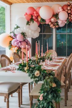 a long table with balloons and candles on it