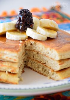 a stack of pancakes topped with bananas and raisins