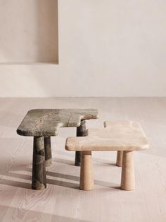 two wooden benches sitting on top of a hard wood floor next to a white wall