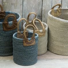 three woven baskets with handles and handles on the sides, one is brown, one is blue