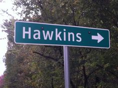 a close up of a street sign with trees in the background