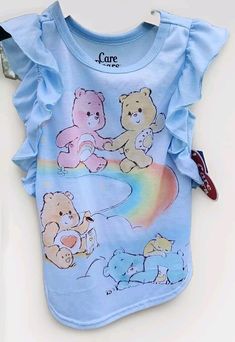 This adorable Care Bears toddler girl's nightgown is perfect for summer and spring nights. The blue flutter sleeve gown in size 2T features the beloved Care Bears characters and is made of lightweight, flame-resistant polyester fabric. The gown is machine washable for easy care and has a cap style sleeve length. The gown is ideal for girls who love the Care Bears theme and is perfect for any young fan of the beloved characters. The gown is made in Cambodia and features the Care Bears brand. It is a great addition to any baby's or toddler's sleepwear collection. Care Bare Pajamas, Carebear Clothes, Care Bears Dress, Care Bears Characters, Carebears Clothes, Care Bears Merch, The Care Bears, Girls Nightgown, Spring Nights