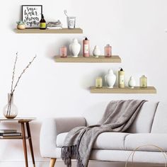 a living room with two shelves on the wall and a couch in front of it