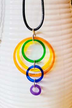 a multicolored necklace hanging from a black cord