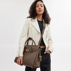 Our Broome has all the effortless cool of its namesake Soho street. The spacious foldover silhouette is crafted of luxe refined leather with a high shine finish and secures with our pushlock “C” closure. Featuring pockets inside and out for easy organization and room for a 16” laptop carry it by hand or use the detachable strap to wear it crossbody. | Coach Broome Carryall Bag 36 - Women's - Brass/dark Stone Leather Satchel With Cc Turnlock Closure And Double Handle, Modern Shoulder Bag With Cc Turnlock For Business, Modern Business Shoulder Bag With Cc Turnlock Closure, Luxury Bags With Cc Turnlock Closure For Work, Luxury Flap Bag With Fold Over Clasp For Work, Modern Leather Satchel With Fold Over Clasp, Luxury Flap Bag With Turn-lock Closure For Work, Chic Shoulder Bag With Cc Turnlock For Business, Luxury Shoulder Bag With Fold Over Clasp For Work