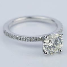 a white gold engagement ring with an oval cut diamond and pave set side stones