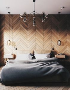 a large bed sitting in the middle of a bedroom next to a wall with wood paneling