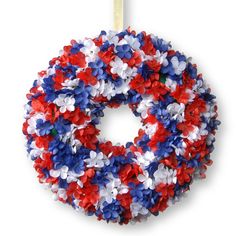 a wreath with red, white and blue flowers is shown in the shape of an american flag