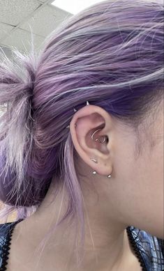 a woman with purple hair and piercings on her ear