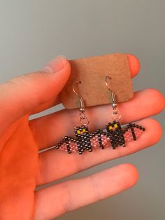 a pair of earrings that are on someone's hand