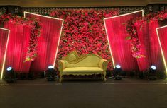 the stage is decorated with red flowers and gold furniture