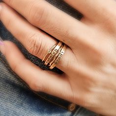 a woman's hand with two gold rings on her fingers