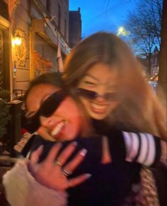 two women hugging each other on the street