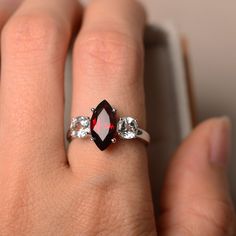 Silver Marquise Ruby Ring For Anniversary, Marquise Ruby Promise Ring With Prong Setting, Silver Marquise Cut Ruby Promise Ring, Marquise Ruby Ring With Accent Stones For Promise, Marquise Cut Garnet Jewelry Gift, Garnet Marquise Cut Jewelry Gift, Marquise Ruby Ring With Center Stone For Promise, Elegant Red Marquise Cut Birthstone Ring, Marquise Garnet Ring For Anniversary