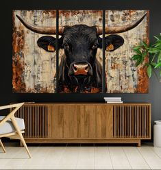 a painting of a cow with horns on it's face is displayed in a living room