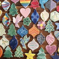 many decorated cookies are arranged on a table with wooden boards in the shape of christmas trees