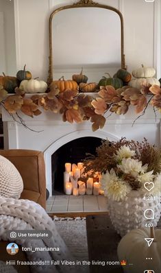 the fireplace is decorated with candles and fall leaves in front of an ornate mirror above it