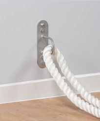 a white rope is attached to a hook on the wall with a gray background and wood floor