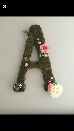 the letters are made out of moss and have flowers on each letter's sides