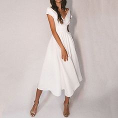 a woman in a white dress posing for the camera