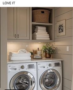 a washer and dryer in a small room with cabinets on the wall above them