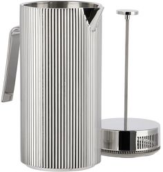 a stainless steel coffee pot next to a cup