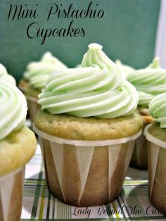 cupcakes with green frosting sitting on a table