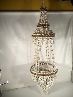 an old chandelier hanging from the ceiling in a room with a white backdrop