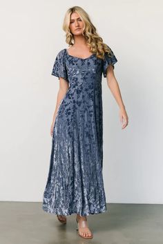 Discover timeless elegance with Everley Velvet Maxi Dress in Whisper Blue, featuring a flattering neckline, short flutter sleeves, and a luxurious velvet floral pattern. This dress effortlessly combines sophistication and femininity, making it a stunning choice for any formal event or evening affair. Blue Floral Wedding Guest Dress, Mother Of The Bride Blue Dresses, Mother Of The Bride Dresses Blue, Blue Gowns Elegant, Blue Mother Of The Bride Dress, Blue Modest Bridesmaid Dresses, Floral Formal Dresses, Velvet Blue Dress, Floral Dress Wedding Guest