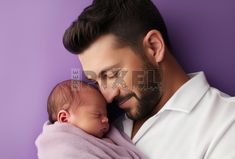 a man holding a baby in his arms while wearing a white shirt and black hair