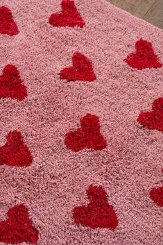 a pink rug with red hearts on it