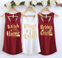 three red and white tank tops hanging on a rack with flowers in the back ground